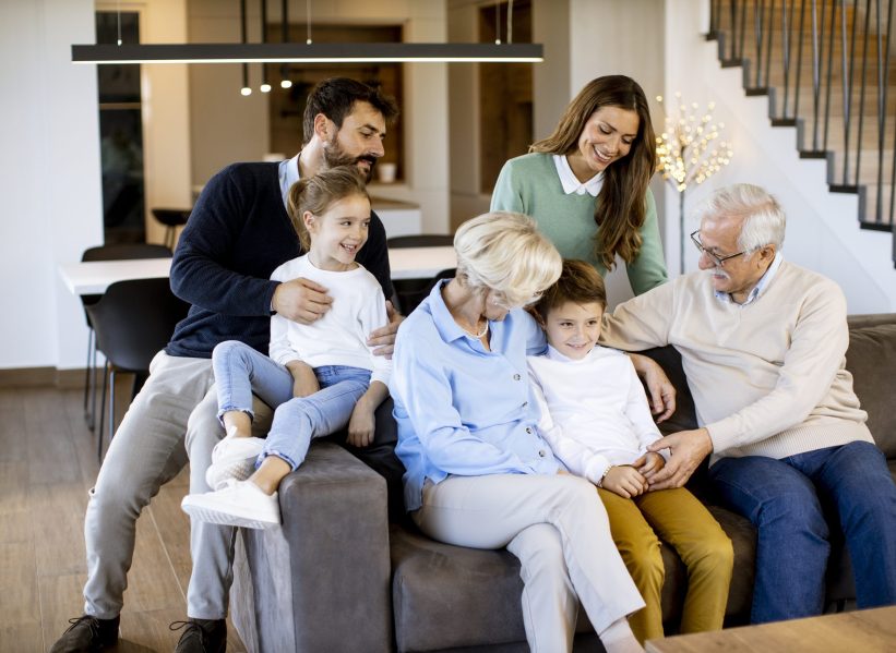 Multi generation family sitting together on the sofa at home and Multi generation family sitting together on the sofa at modern home and watching TV